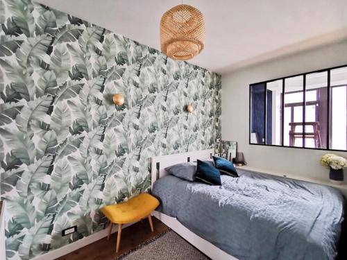 ein Schlafzimmer mit einem Bett und einem Wandbild in der Unterkunft Appartement rénové une chambre avec espace de travail in Suresnes