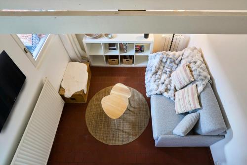 an overhead view of a living room with a couch and a table at Le Petit Gîte - Confort & Elegance - Parking & WIFI - Calme & Jardin in Verlinghem