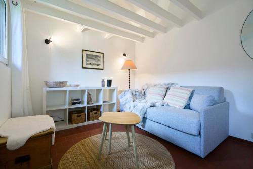 a living room with a blue couch and a stool at Le Petit Gîte - Confort & Elegance - Parking & WIFI - Calme & Jardin in Verlinghem