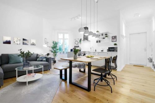 ein weißes Wohnzimmer mit einem Tisch und einer Küche in der Unterkunft Gesamte Unterkunft Apartment in Ludwigslust in Ludwigslust