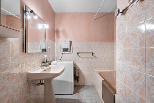 Appartement Tout Confort في ليه ليكيه: حمام مع حوض ومرحاض وحوض استحمام