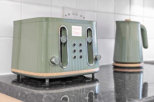 a green toaster sitting on top of a counter at Bella Homes-Spacious 4 bedroom Modern Town house Romford in Romford