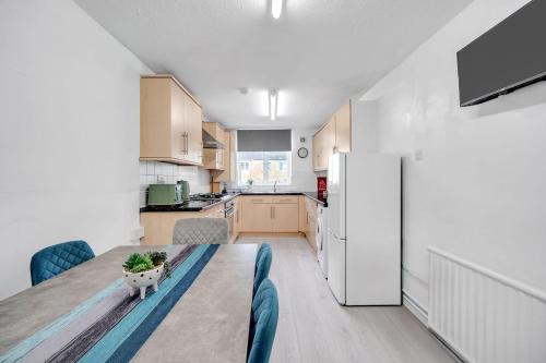 a kitchen with a table with a potted plant on it at Bella Homes-Spacious 4 bedroom Modern Town house Romford in Romford