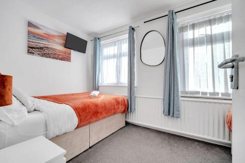 a small bedroom with a bed and a window at Bella Homes-Spacious 4 bedroom Modern Town house Romford in Romford