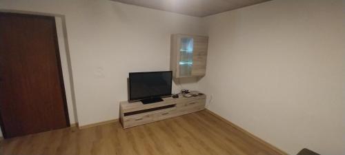 ein Wohnzimmer mit einem Flachbild-TV auf einer Kommode in der Unterkunft KaTi Hiša 
