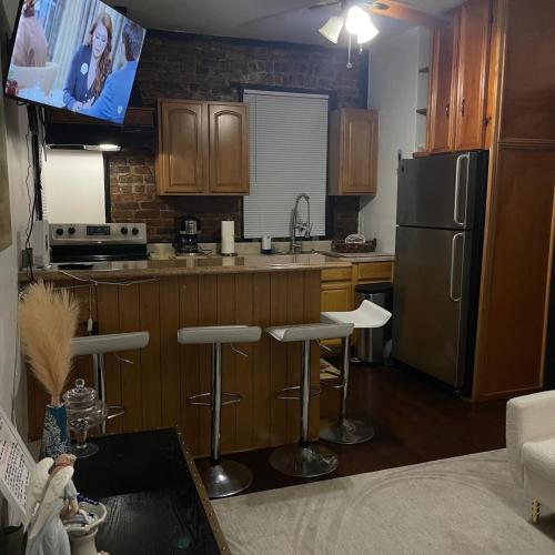 a kitchen with a stainless steel refrigerator and bar stools at Comodo y economico Apartamento in North Beach