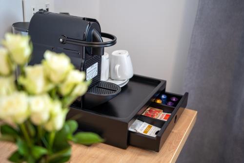 a coffee machine sitting on a table with flowers at No Pardon Hotel in Satu Mare