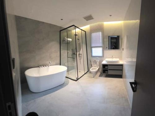 ein Badezimmer mit Badewanne und Dusche und Toilette in der Unterkunft NEW Luxury 6BR Pool Villa Pattaya, 10mn Walking St in Jomtien Beach