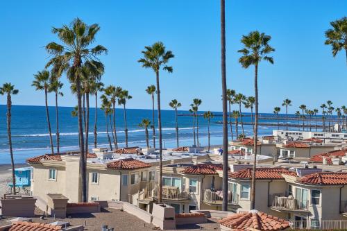 a row of houses on the beach with palm trees at 501P-12 Spectacular Ocean Views Pet Friendly in Oceanside