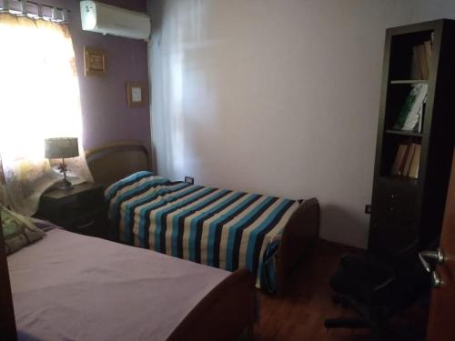 ein Hotelzimmer mit 2 Betten und einer gestreiften Decke in der Unterkunft Chalet y rio in Villa Carlos Paz