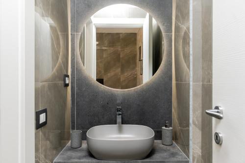 Un baño con un lavabo blanco y un espejo. en Nova Suite, en Catania