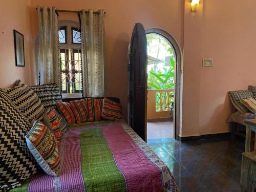 un salon avec un canapé et une fenêtre dans l'établissement Anjuna Hideout, à Anjuna