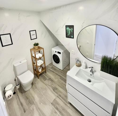 a bathroom with a sink and a toilet and a tv at Apartamento Vive Zaragoza V in Zaragoza