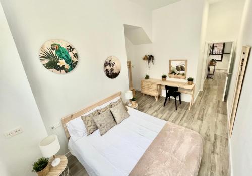 a white bedroom with a bed and a desk at Apartamento Vive Zaragoza V in Zaragoza