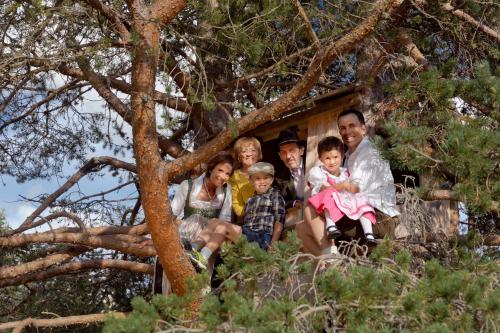 a family sitting in front of a tree at Hotel Gran Paradiso in San Cassiano