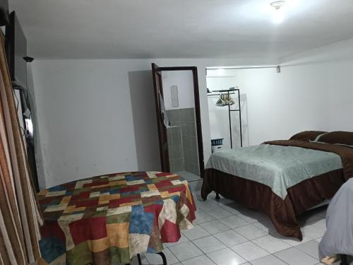 1 dormitorio con cama y espejo. en Cobán room, en Cobán