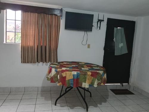 Habitación con silla y TV de pantalla plana. en Cobán room, en Cobán