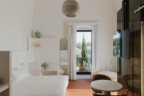 ein weißes Wohnzimmer mit einem weißen Sofa und einem Tisch in der Unterkunft Mastropà Exclusive Resort in Massafra