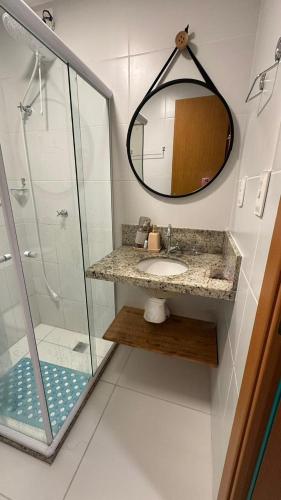 a bathroom with a sink and a mirror at Guarajuba Acqua 103 in Camacari