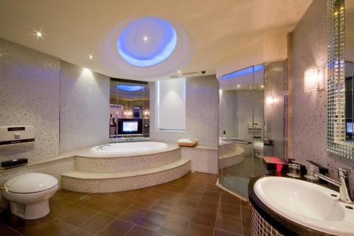 a bathroom with a tub and a toilet and a sink at Wego Hotel - Linsen in Taipei