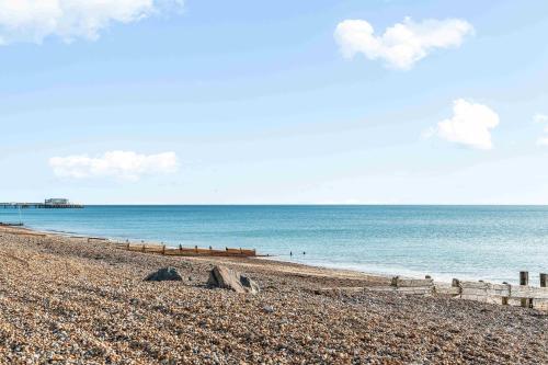 a beach with a fence and the ocean at Queens Cove with Seaviews By My Getaways in Worthing
