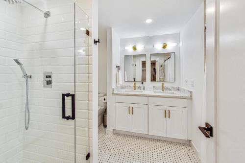 a white bathroom with a shower and a sink at Luxurious Lincoln Park Home with Gourmet Kitchen in Chicago