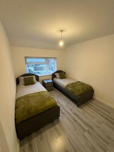 une chambre avec deux lits et une fenêtre dans l'établissement Blackthorne House, à Birmingham