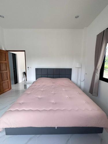 a large pink bed in a white room with a window at Grandma's Samui Garden - บ้านสวนคุณย่า in Ban Tai