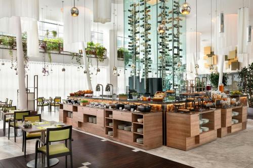a restaurant with a buffet with tables and chairs at Sheraton Milan Malpensa Airport Hotel & Conference Centre in Ferno
