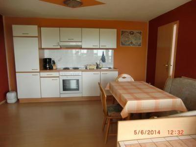 a kitchen with a table and a kitchen with white cabinets at Ferienhaus Am See in Radewege