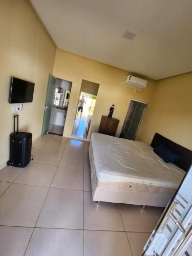 a bedroom with a bed and a tv in it at Chácara de vidro in Canindé de São Francisco
