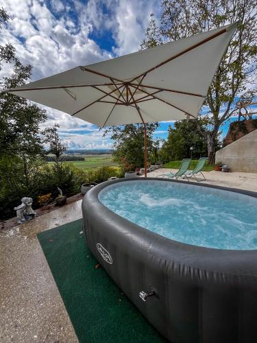 a pool with an umbrella and two chairs and a table at Vila Vinita in Sveti Jurij ob Ščavnici