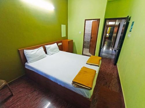 une chambre avec un grand lit aux murs verts dans l'établissement The Golden Seaview - Homestay, à Gokarna