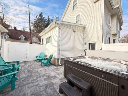 a backyard with a hot tub on a patio at Heron Hideaway Game Room within walking distance to HWS & Seneca Lake in Geneva