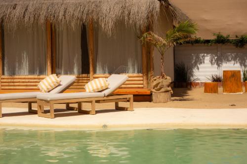 a resort with two lounge chairs and a swimming pool at Tribu Eco Beach in Francisco Álvarez
