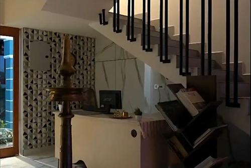 科钦G Hotels And Resorts的一个房间里有楼梯，楼梯下面有一张桌子。