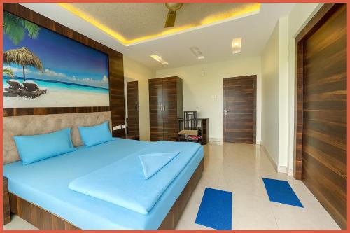 普里BALCONY ROOMS Hotel PREMIUM RR RESIDENCY Near Jagannath Temple - Sea Beach 5 minute walking distance - Bangali Market- Lift-Parking And Restaurant Facilities -Prime Location - Fully Air Conditioning Luxuary Rooms - Top Rated Hotel In Puri的一间卧室,卧室内配有一张蓝色大床