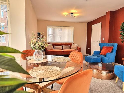 a living room with a glass table and chairs at 3-Bedroom New Build House with Parking, Garden & Transport Links with Long Stay Offers in Thurcaston