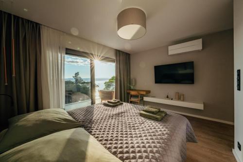 ein Schlafzimmer mit einem großen Bett mit einem großen Fenster in der Unterkunft Villa Harmony Brela in Brela