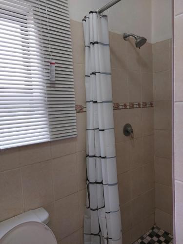 a bathroom with a shower and a toilet at Mandy & Mos' Greenfields Cottage in Gaborone