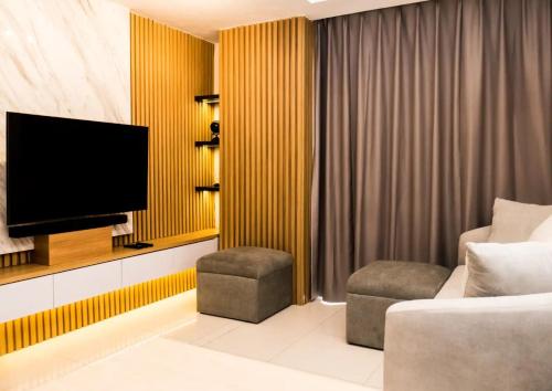 ein Wohnzimmer mit Fernseher und Sofa in der Unterkunft 1 BD AT Coastal Skyline in Hongkong