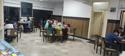 Un grupo de personas sentadas en mesas en una habitación. en Hotel Mount Heaven, en Murree