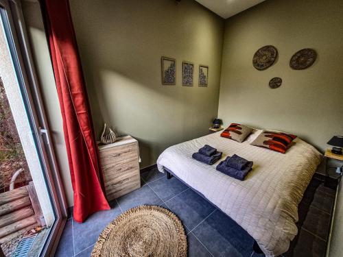 une chambre avec un lit et une grande fenêtre dans l'établissement Terrasse couverte et BBQ - Petite maison cosy, à Magnet