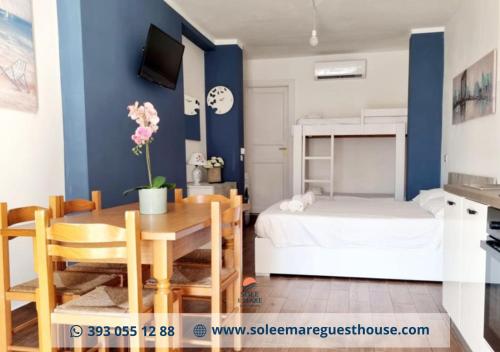 Habitación con mesa de comedor y cama en Sole E Mare, en Guardia Piemontese Terme