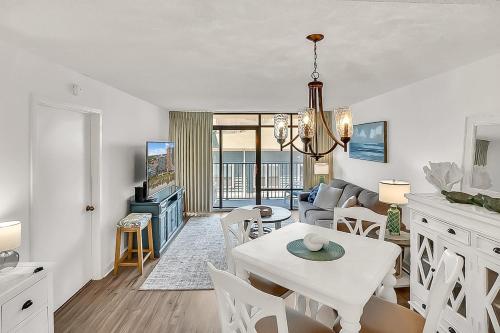 een keuken en woonkamer met een witte tafel en stoelen bij Verandas 407 in Myrtle Beach
