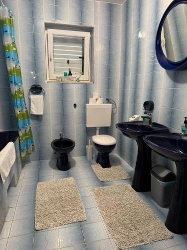 a bathroom with two sinks and a toilet and a mirror at Apartments Solis, 50 m from the sea - Jakišnica in Jakišnica