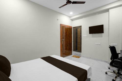 DurgにあるHOTEL O CROWDのベッドと壁にテレビが掛かった寝室