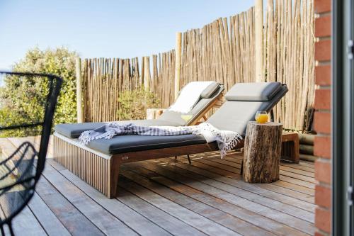 a bench on a deck with a fence at RRoar George in Herolds Bay