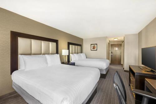 a hotel room with two beds and a television at Best Western Plus Waterfront Hotel in Windsor