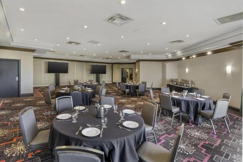 a conference room with tables and chairs and a screen at Best Western Plus Waterfront Hotel in Windsor